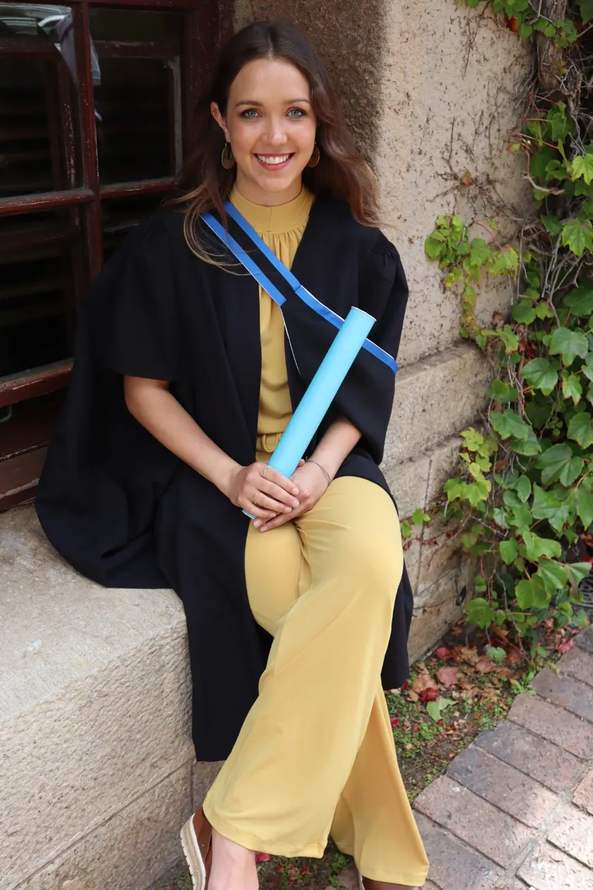 Kirsty in her graduation gown, holding her degree