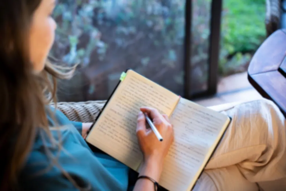 A hand writing in a journal