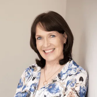 Nikki Sinclair, smiling, arms folded